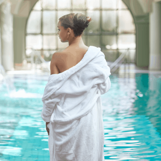 Lady in a white gown standing by the spa pool